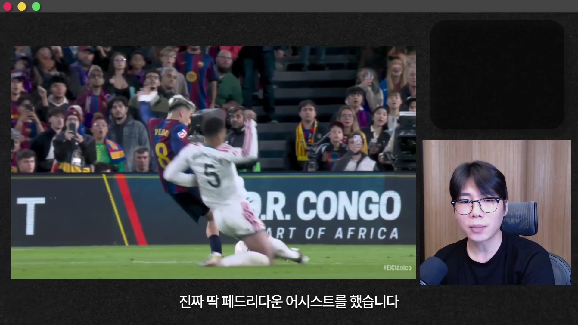 경기 장면이 재생되는 비디오 프레임 옆에 안경을 쓴 남성이 앉아 있는 모습이 보입니다.