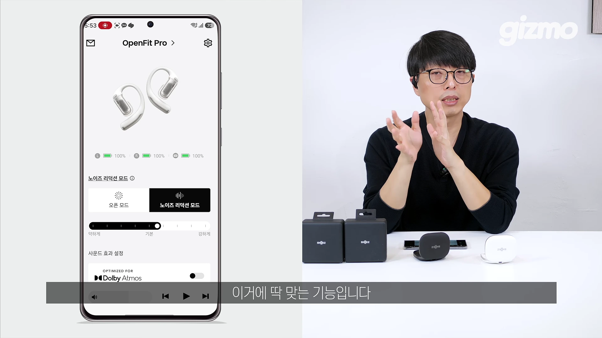 안경을 쓴 남성이 테이블 앞에 앉아 손짓하며 설명하고 있고, 왼쪽 화면에는 무선 이어폰 전용 앱의 노이즈 리덕션 설정 인터페이스가 표시되어 있다.