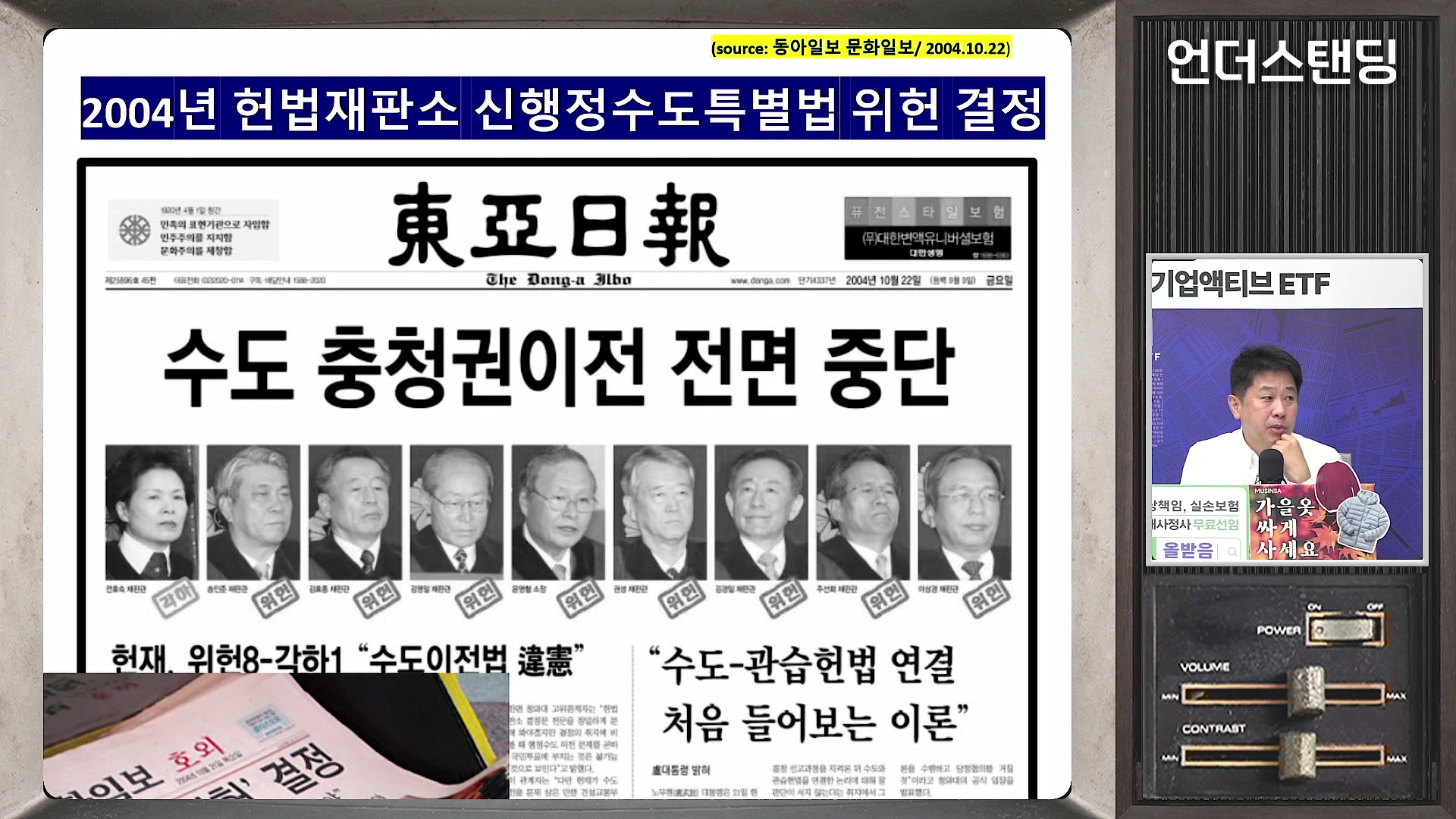 2004년 10월 22일 자 동아일보 1면 헤드라인이 강조된 뉴스 자료 화면으로, '수도 충청권 이전 전면 중단'이라는 기사 제목과 당시 헌법재판관들의 인물 사진이 나란히 배치되어 있다.