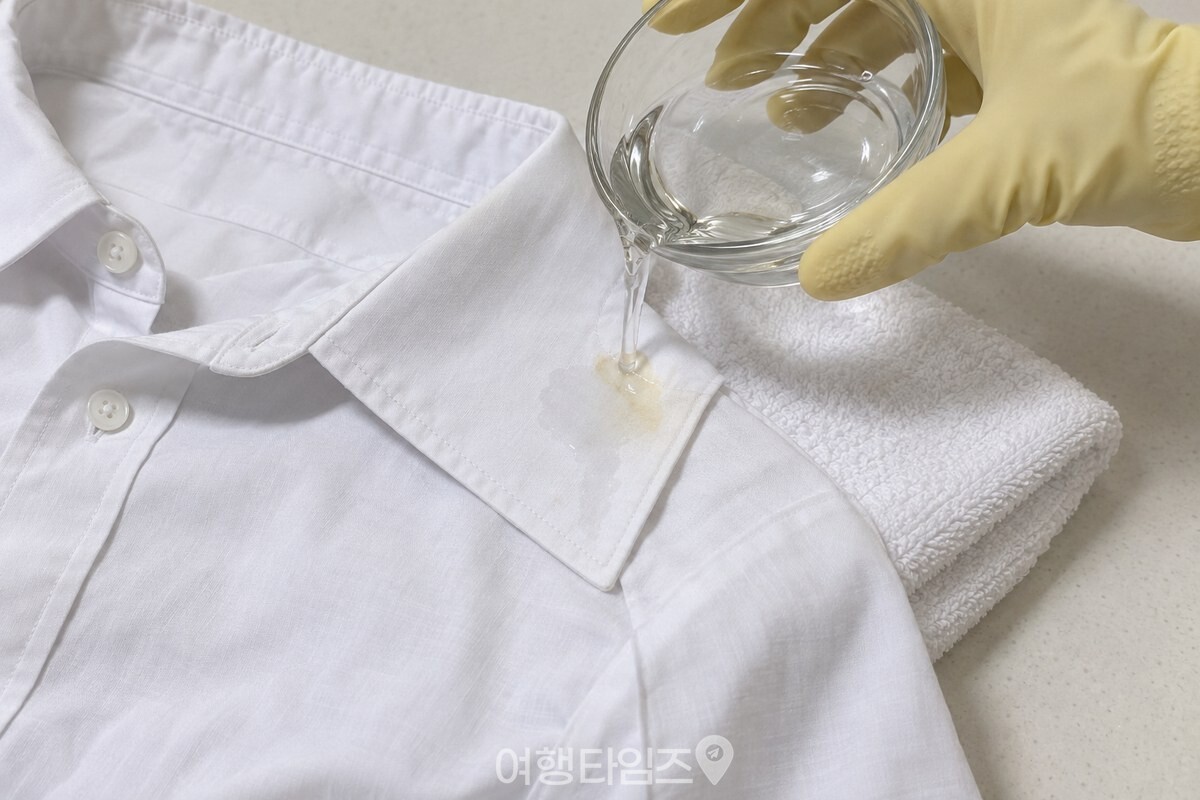 수건 위 흰 셔츠 자국에 희석액을 적시는 모습 / 기사 이해를 돕기 위한 생성형 이미지