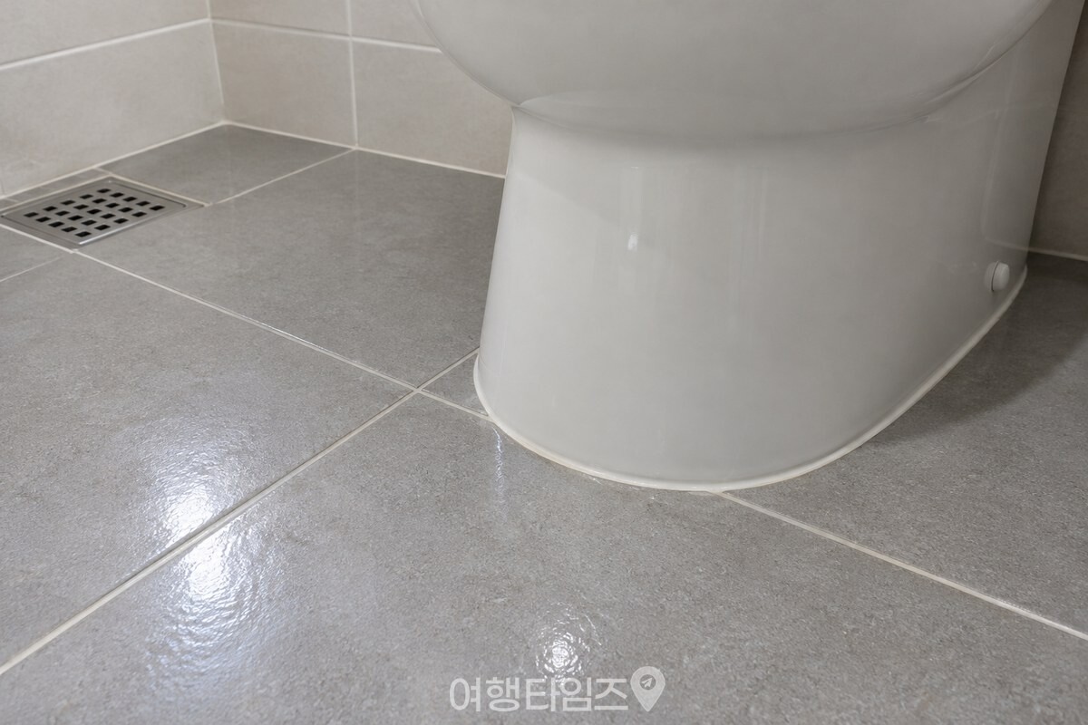 일반 도기 타일 바닥과 변기 재질을 가까이에서 확인하는 모습 / 기사 이해를 돕기 위한 생성형 이미지
