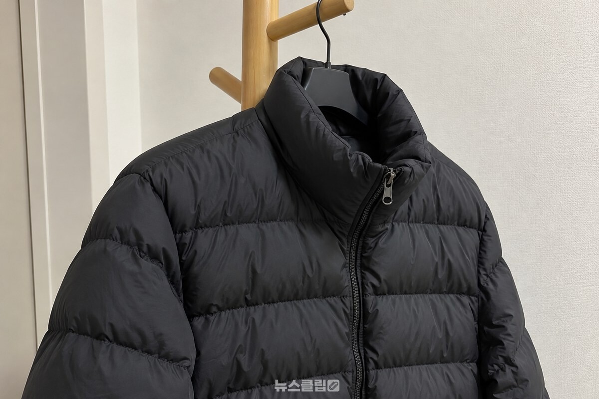 목둘레와 앞판 원단 결이 보이는 검은 패딩 겉감 / 기사 이해를 돕기 위한 생성형 이미지