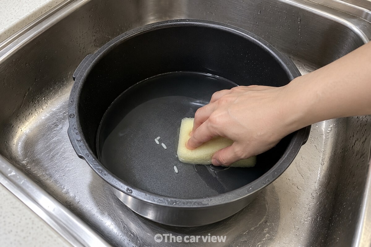 부드러운 스펀지로 내솥 바닥을 닦는 모습 / 기사 이해를 돕기 위한 생성형 이미지