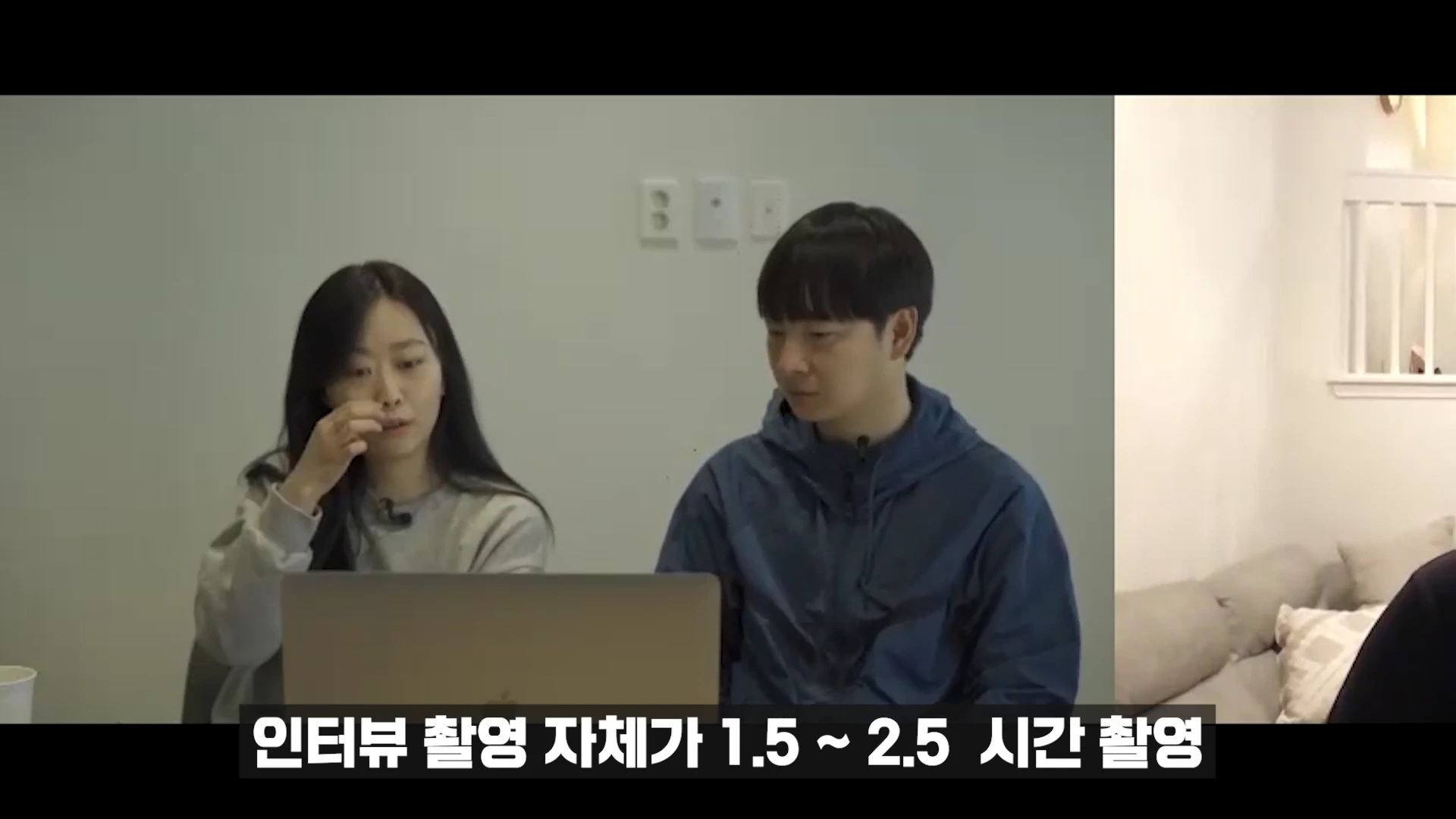 실내에서 노트북을 함께 보고 있는 남녀의 모습이 담긴 인터뷰 영상의 한 장면으로, 하단에는 '인터뷰 촬영 자체가 1.5~2.5 시간 촬영'이라는 자막이 적혀 있습니다.