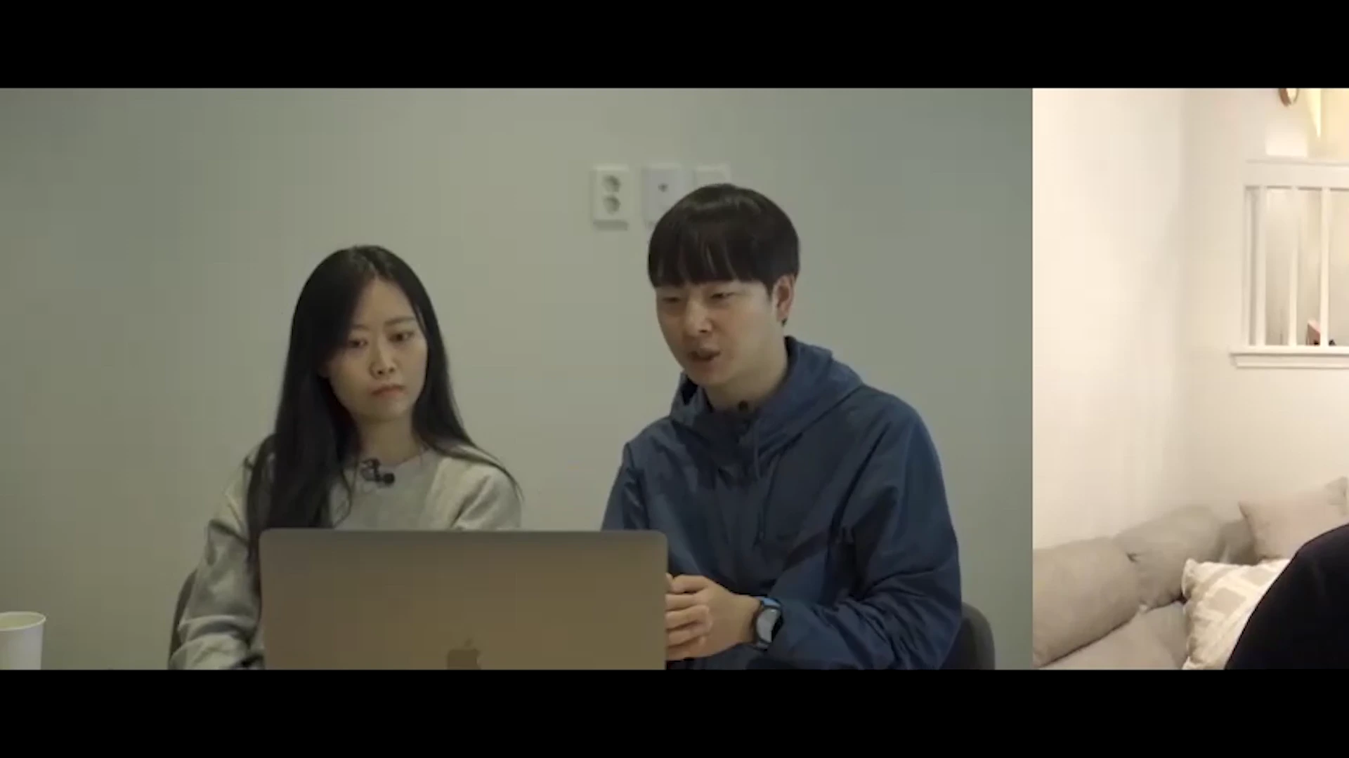 실내에서 노트북 화면을 함께 들여다보며 이야기를 나누는 남녀의 모습이 담긴 인터뷰 영상의 한 장면입니다.