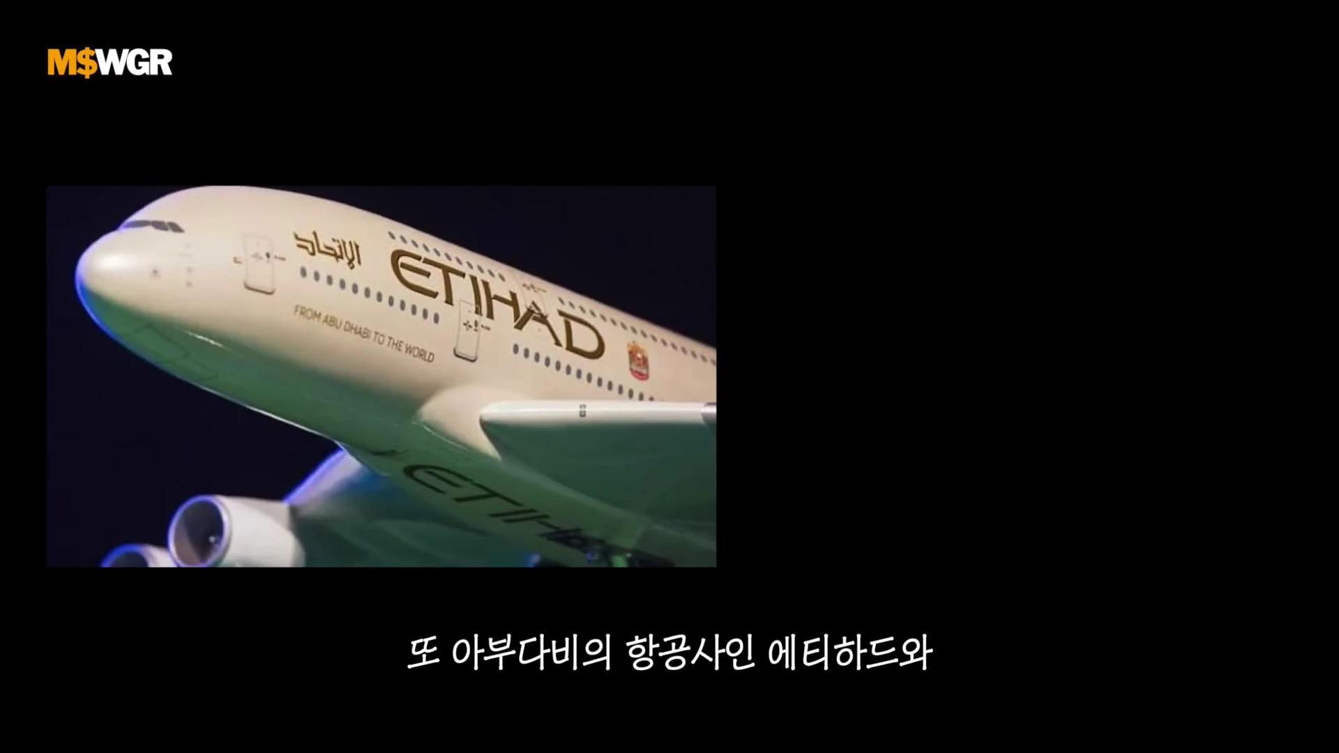 에티하드 항공 로고가 측면에 크게 새겨진 여객기 동체 앞부분이 어두운 배경 속에 비스듬히 놓여 있는 모습.