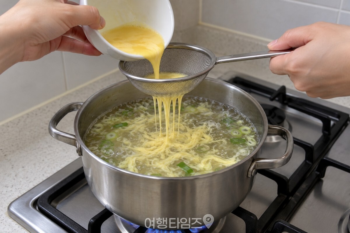 긴 손잡이 채망으로 끓는 국물에 달걀물을 내려 넣는 모습 / 기사 이해를 돕기 위한 생성형 이미지