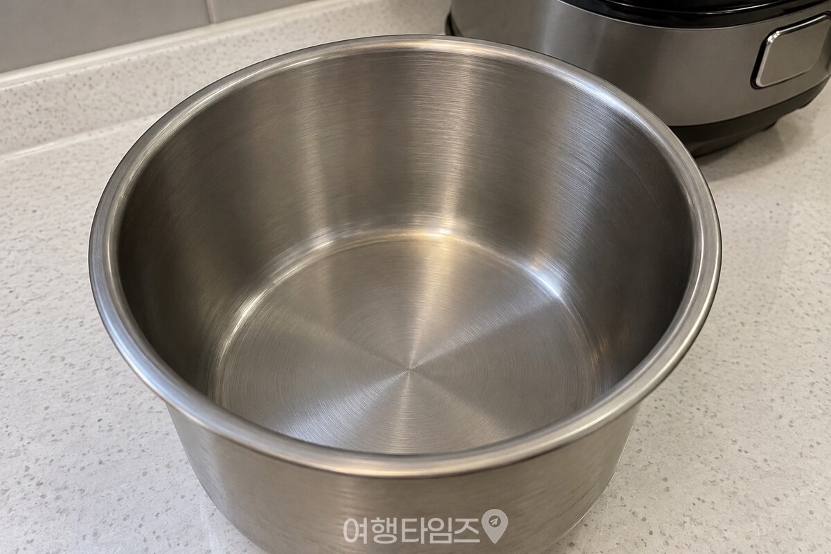 은색 금속 표면이 보이는 빈 스테인리스 밥솥 내솥 / 기사 이해를 돕기 위한 생성형 이미지