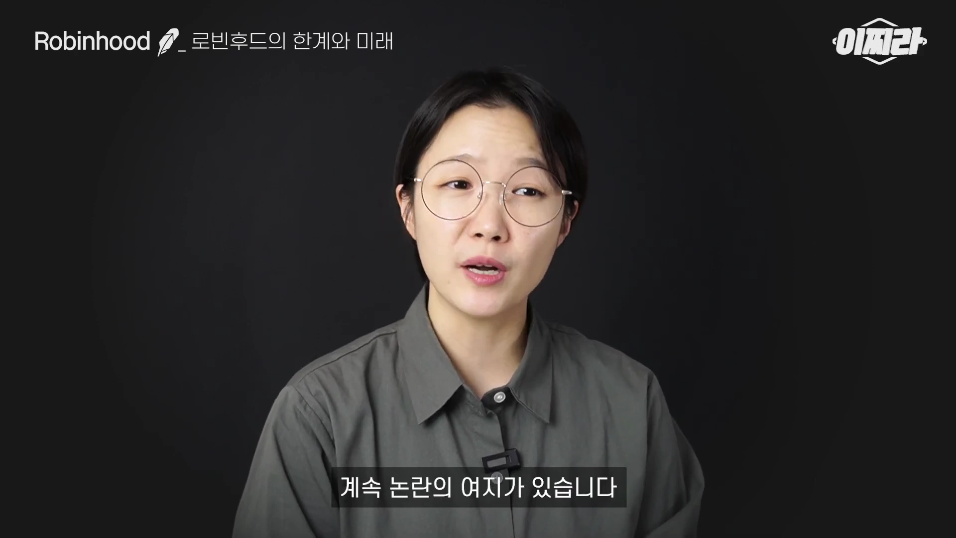 검은색 배경 앞에서 안경을 쓴 여성이 말하고 있으며, 화면 왼쪽 상단에는 로빈후드 제목이, 하단에는 '계속 논란의 여지가 있습니다'라는 자막이 표시된 영상 프레임입니다.