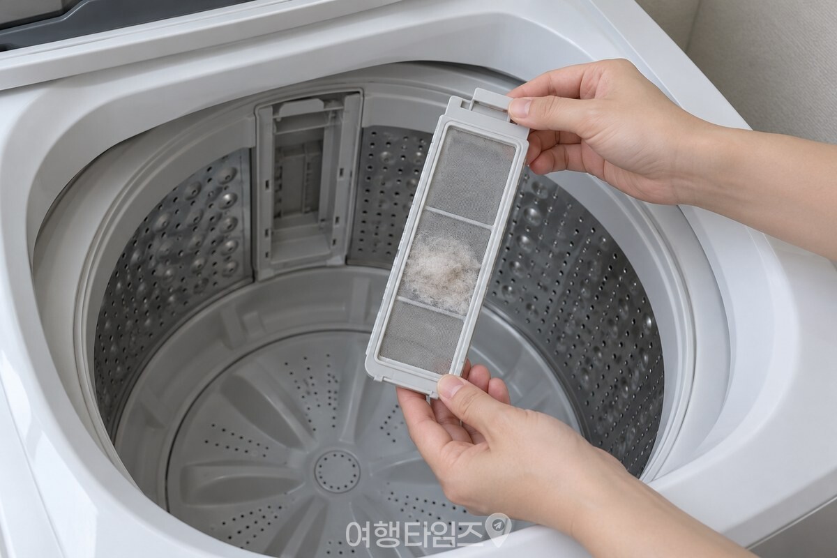통돌이 세탁기 안쪽 벽의 먼지 거름망을 꺼내는 모습 / 기사 이해를 돕기 위한 생성형 이미지