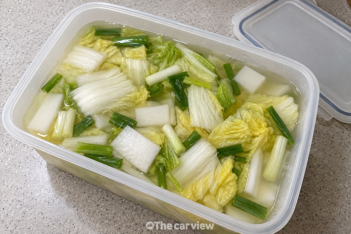 맑은 국물과 배추, 무가 담긴 막 담근 물김치 통 / 기사 이해를 돕기 위한 생성형 이미지