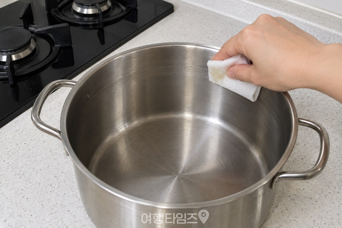 식은 냄비 안쪽 테두리에 기름 띠를 바르는 손 / 기사 이해를 돕기 위한 생성형 이미지