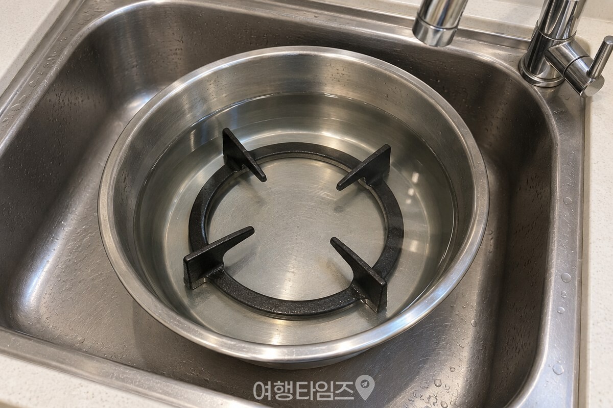 따뜻한 워싱소다 물에 잠긴 검은 가스레인지 삼발이 / 기사 이해를 돕기 위한 생성형 이미지