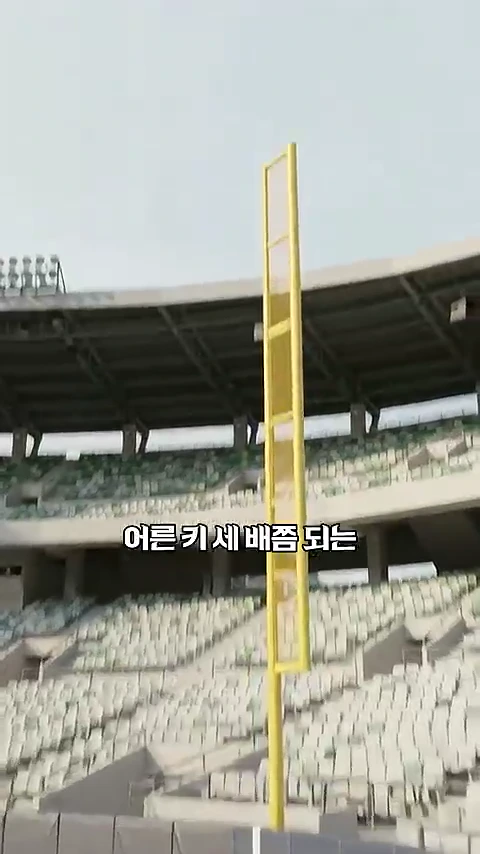 잠실 올림픽주경기장의 관중석 배경으로 노란색 폴대와 펜스가 설치된 모습