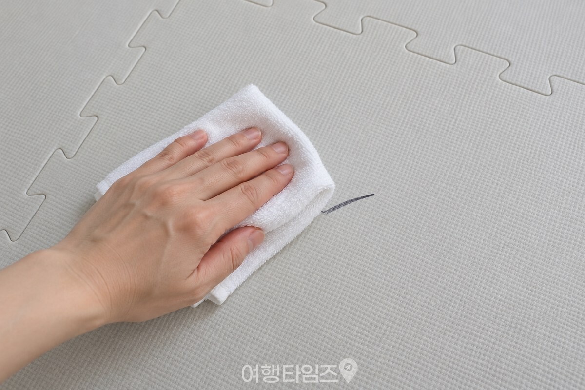 깨끗한 놀이 매트의 작은 유성매직 선을 마른 천으로 닦는 모습 / 기사 이해를 돕기 위한 생성형 이미지