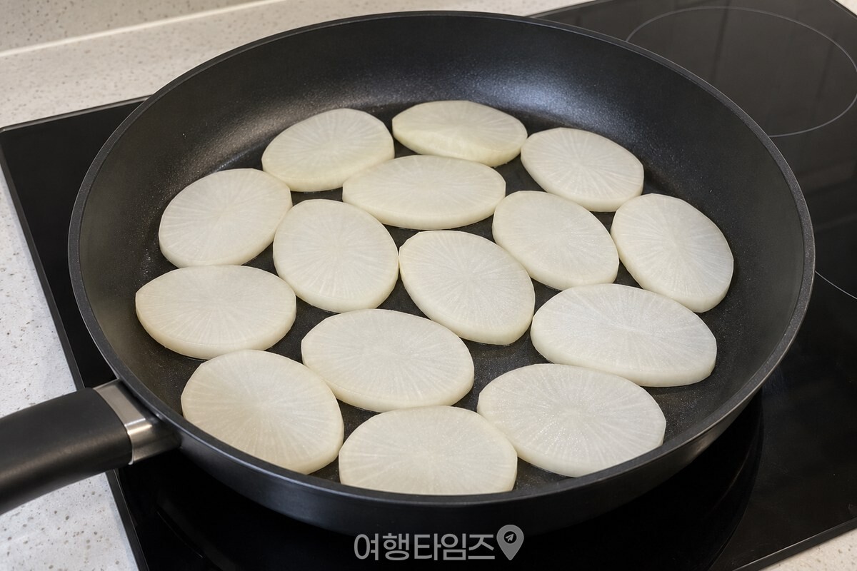 얇게 썬 무가 팬 바닥에 한 겹 놓인 모습 / 기사 이해를 돕기 위한 생성형 이미지