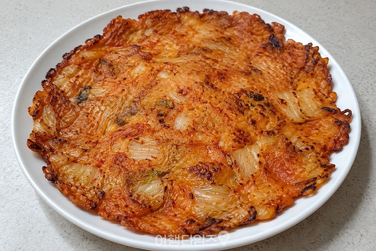 접시에 담아낸 노릇한 김치전 / 기사 이해를 돕기 위한 생성형 이미지