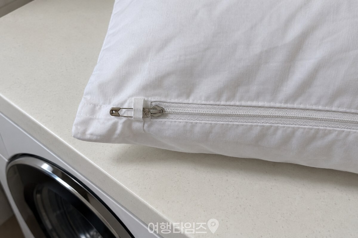 닫은 베개 커버 지퍼 손잡이를 천에 고정한 작은 안전핀 / 기사 이해를 돕기 위한 생성형 이미지