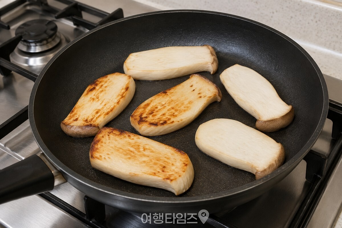 마른 팬에서 양면을 먼저 굽는 새송이버섯 조각 / 기사 이해를 돕기 위한 생성형 이미지