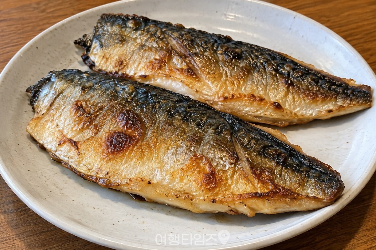 노릇하게 구워진 고등어를 팬에서 꺼내는 모습 / 기사 이해를 돕기 위한 생성형 이미지