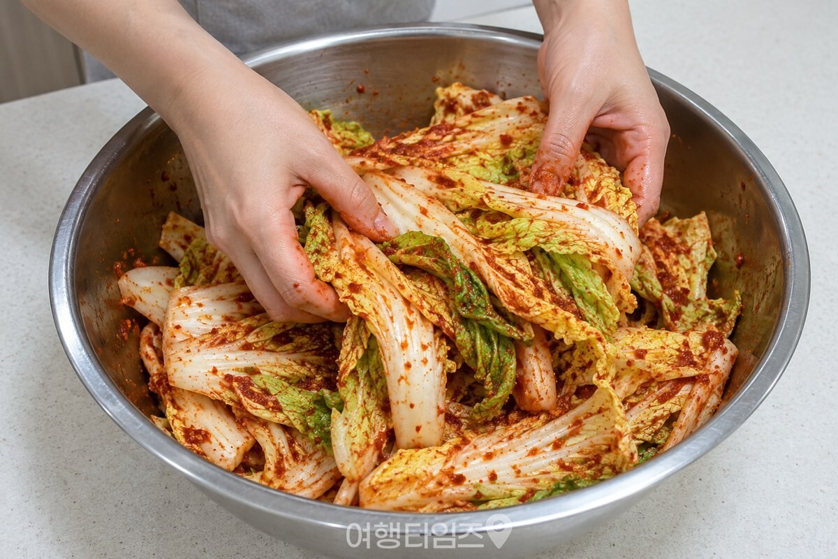양념 묻은 알배추를 아래에서 들어 올려 버무리는 손 / 기사 이해를 돕기 위한 생성형 이미지